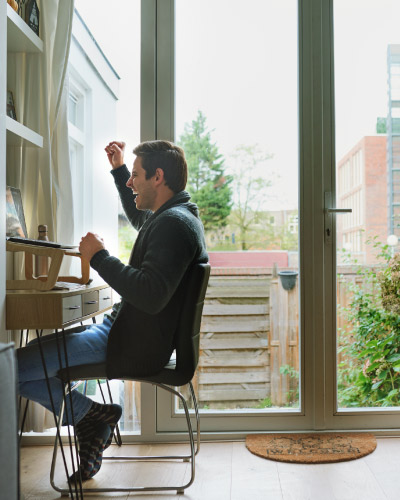 Man celebrating while sitting in front of his computer