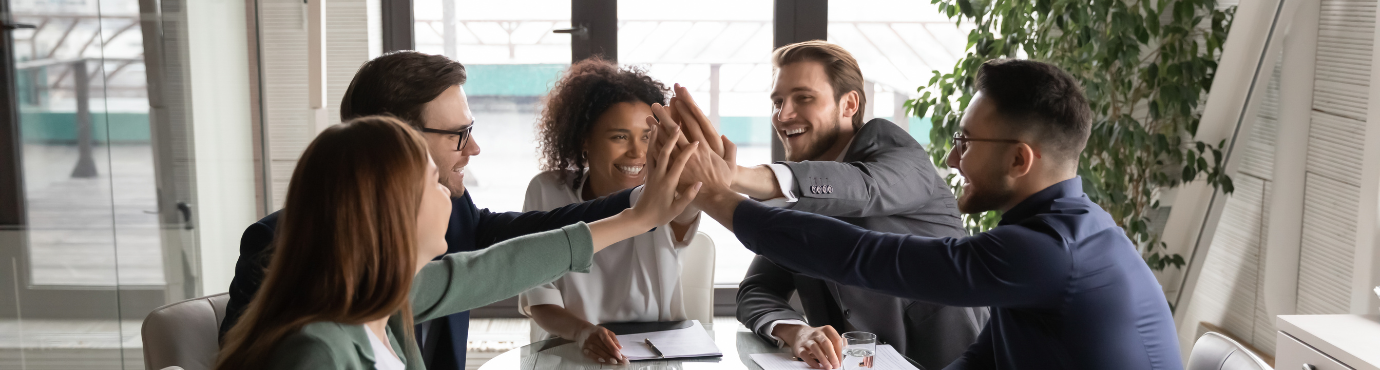 people giving a high five around a table